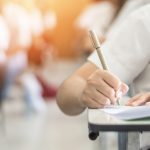 Exam with school student having a educational test, thinking hard, writing answer in classroom for  university education admission and world literacy day concept