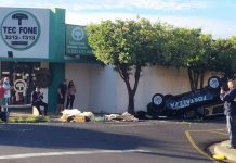 Carro de funerária capota ao ser atingido em cruzamento e caixão com corpo é arremessado para fora